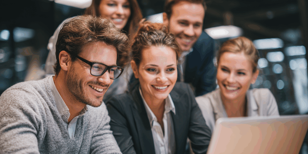 Happy business team watching videos on laptop